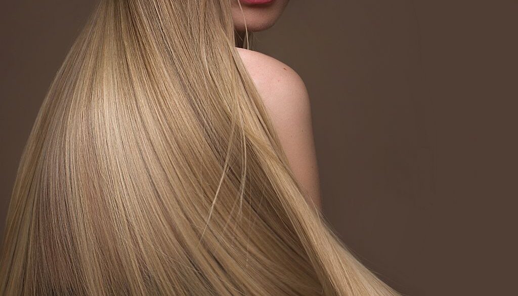 Beautiful blond girl with a perfectly smooth hair, classic make-up. Beauty face